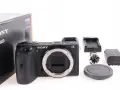 Aparat Sony Alpha 6600 z akcesoriami: pudełko, ładowarka, bateria, kabel i dekielek.