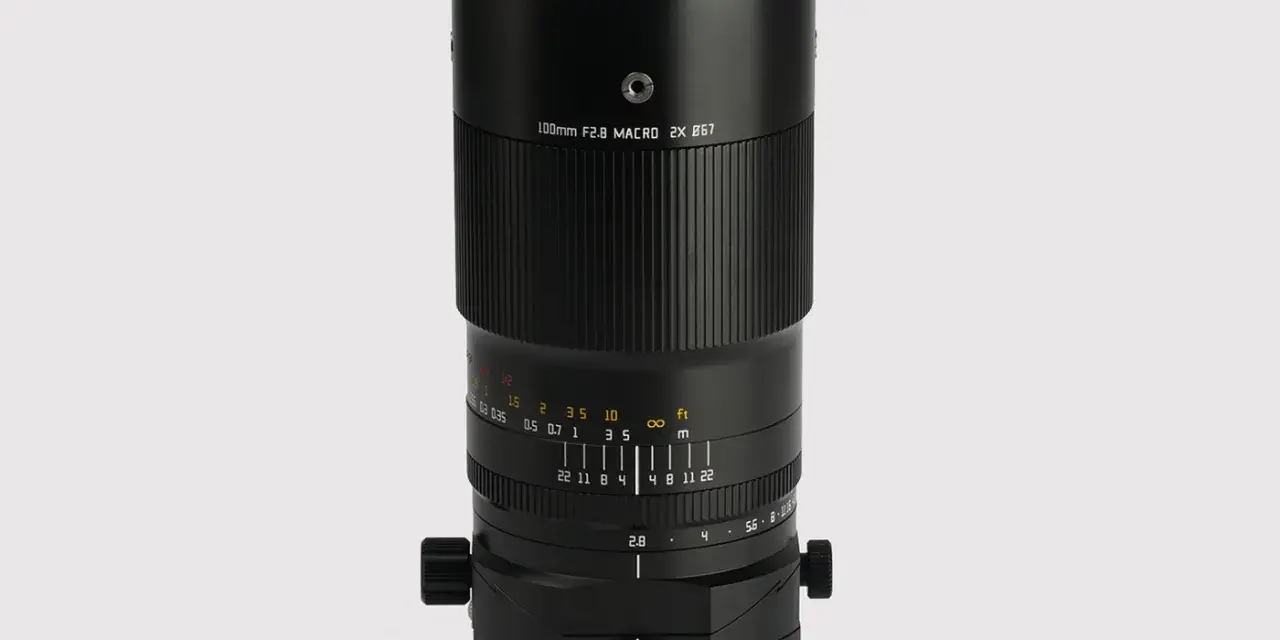 Czarny obiektyw makro 100mm f/2.8 z oznaczeniami odległości i przysłony.