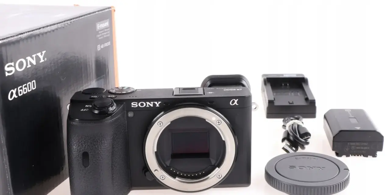 Aparat Sony Alpha 6600 z akcesoriami: pudełko, ładowarka, bateria, kabel i dekielek.